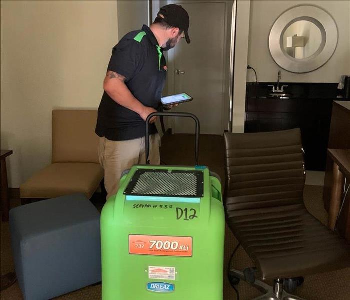 Team member setting up a dehumidifier.